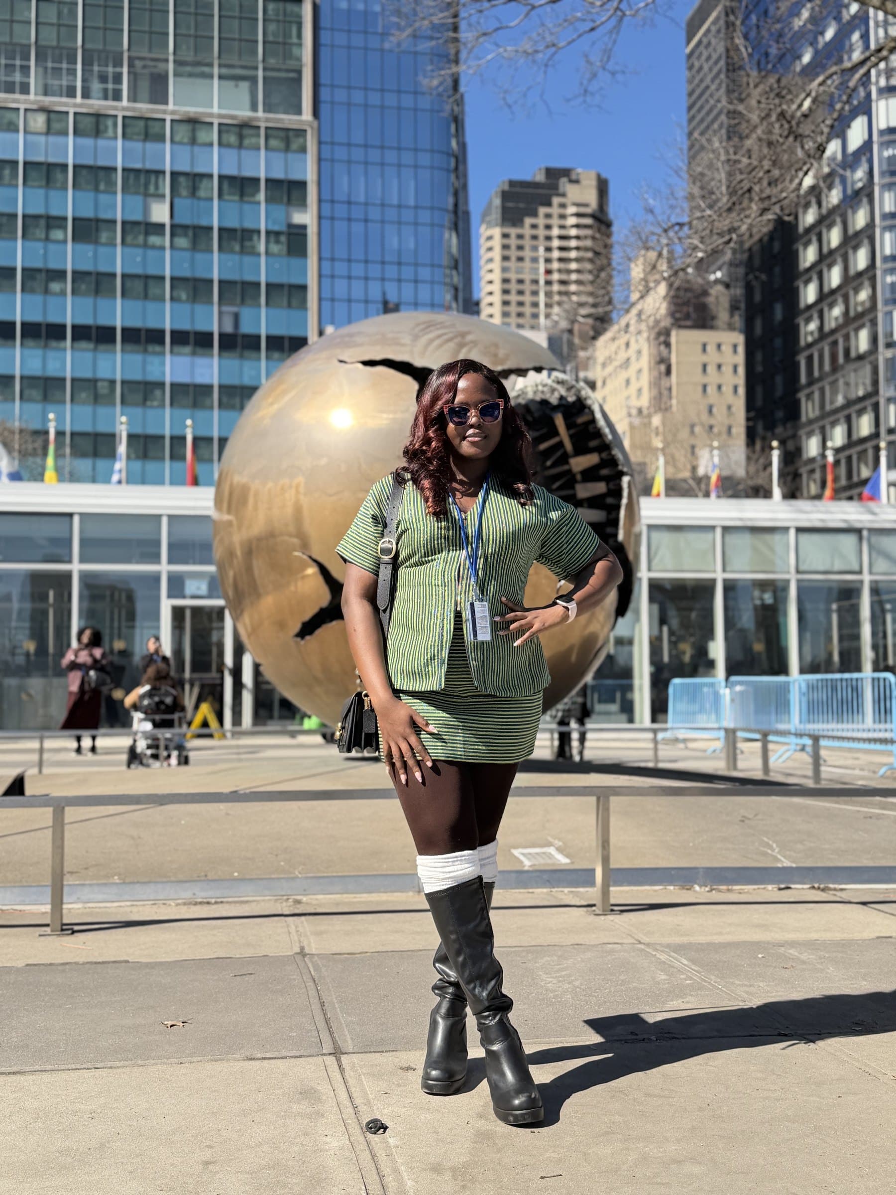 Taslemat Yusuf outside UN Headquarters in front of the sphere sculpture